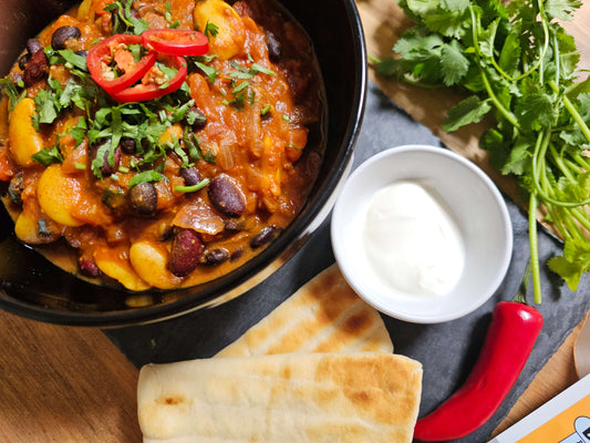 close up of three bean curry in black bowl